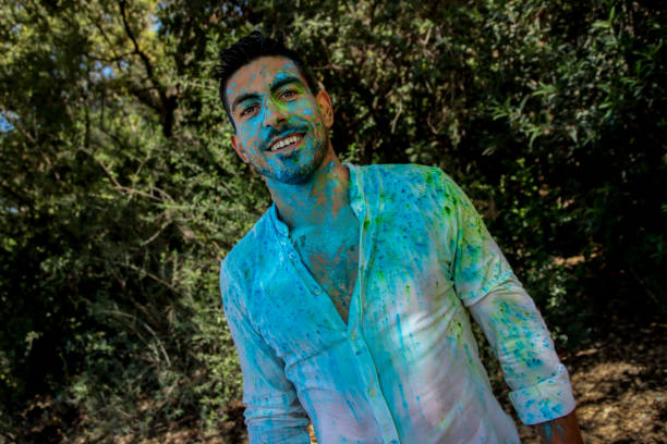 istock Young man covered in holi powder at the park 1576788204