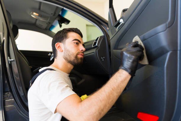 istock Handsome worker polishing car interior at auto detail workshop 1576788205