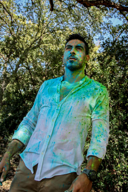 istock Young man covered in holi powder at the park 1576788214