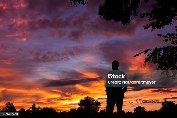 Foto de Silhueta De Homem Observa Espetacular Céu Durante A Colorida Do Nascer Do Sol De Manhã Cedo e mais fotos de stock de 55-59 anos