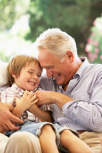 istock Grandfather With Grandson Laughing Together On Sofa 157679111