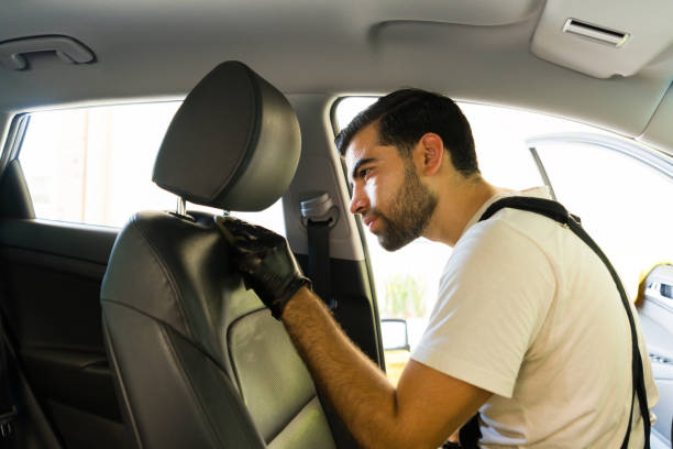 istock Worker cleansing vehicle upholstery at car wash 1576791308