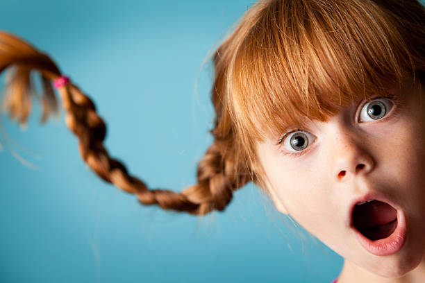 Red-Haired Girl with Upward Braids and Look of Surprise Color photo of a silly, red-haired girl with upward braids and a look of surprise! gasping stock pictures, royalty-free photos & images
