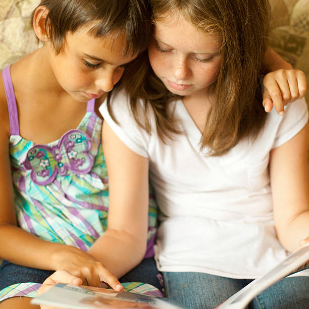 istock Two sisters reading a magazin together 157679366