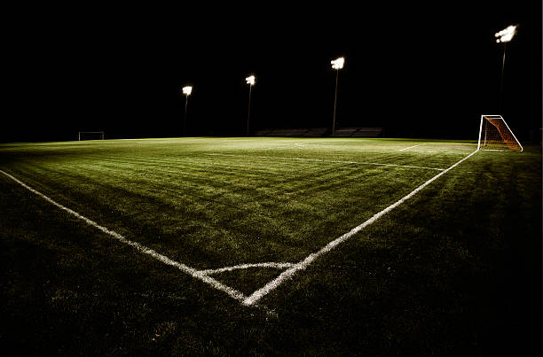 Soccer Field at Night Groomed soccer field or soccer pitch at night.  Real, green grass, stadium style lighting and dark skies isolate the field from its surroundings.  The field is empty with no players. baseline stock pictures, royalty-free photos & images