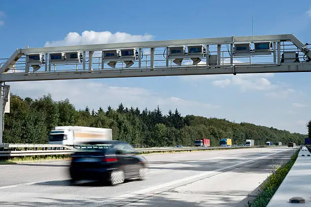 German highway - control gantry/bridge with passing cars and trucks