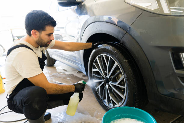 istock Car wash employee washing car wheels 1576795964