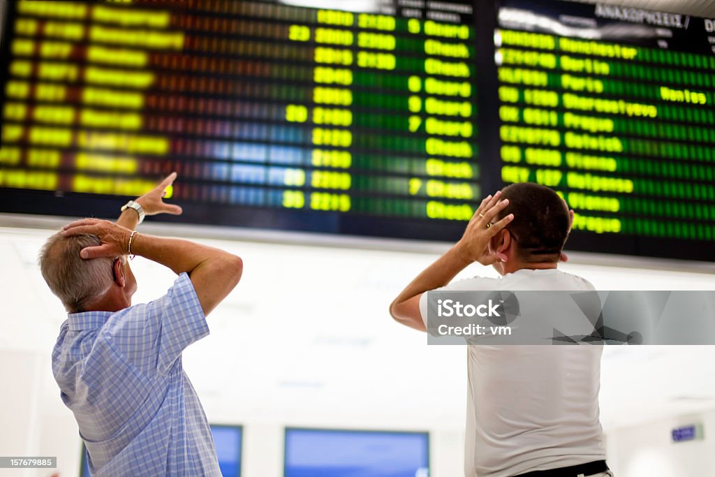 Due frustrato uomo guardando scheda - Foto stock royalty-free di Aeroporto