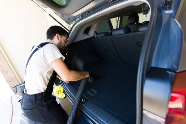 istock Car wash worker vacuuming the car trunk 1576800628