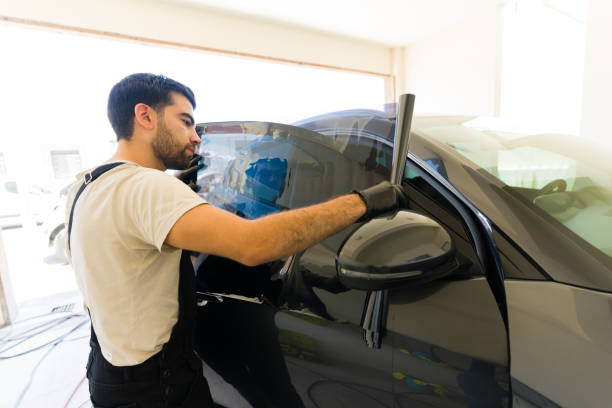 istock Specialist installing car tint on vehicle window at workshop 1576800636