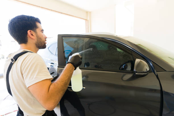 istock Professional installer preparing car window for tinting at auto detail service 1576800642