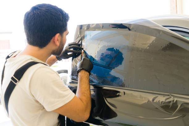 istock Specialist installing tinting film on car window 1576801157