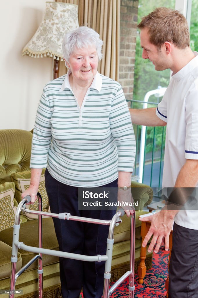 Enfermera ayudando a senior mujer a su cuadrados - Foto de stock de 80-89 años libre de derechos