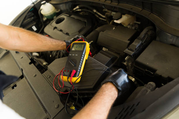 istock Mechanic checking battery with multimeter at garage 1576801678