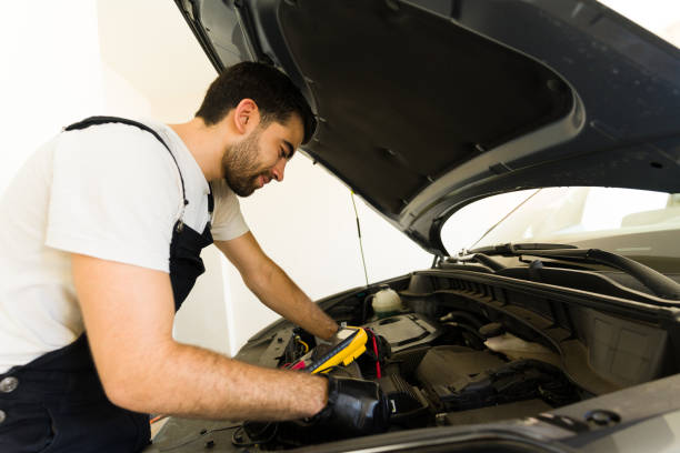 istock Car mechanic checking the voltage of battery using voltmeter at garage 1576802183