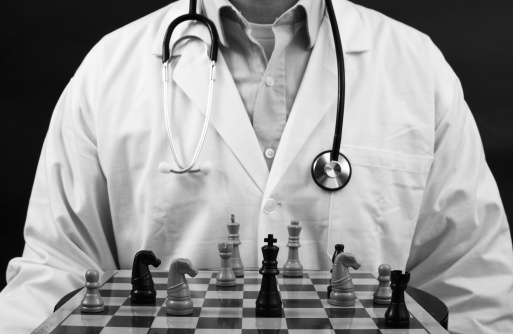 a medical doctor with a chess game board and pieces.