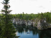 Blue lake and marble rocks with pine forest.