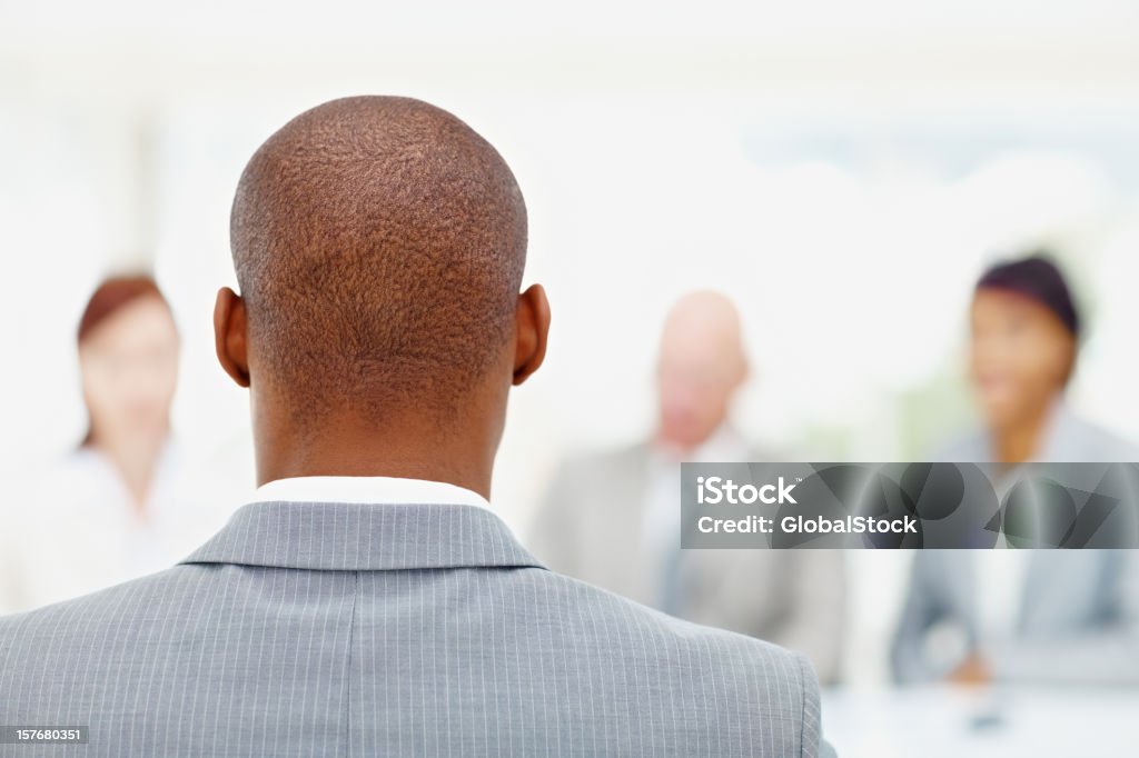 Um afro-americano homem de negócios e sua equipe em segundo plano - Foto de stock de Entrevista de Trabalho royalty-free