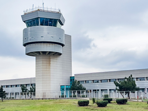 Modern air traffic control tower at Bodrum airport on cloudy day. Low angle view. Air travel background, copy space.
