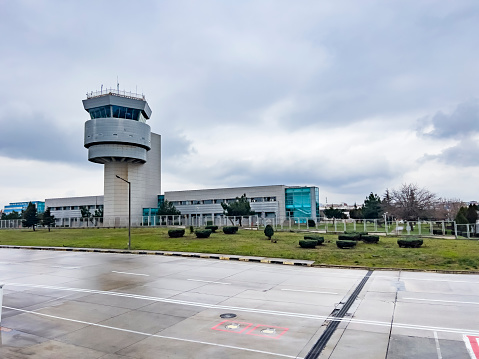 Modern air traffic control tower at Bodrum airport on cloudy day. Low angle view. Air travel background, copy space.