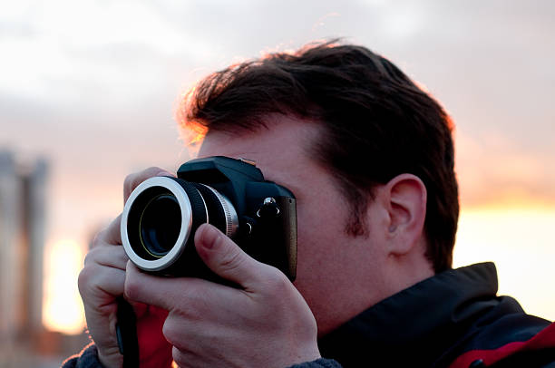 istock Photographer holding professional camera, at sunset 157680500