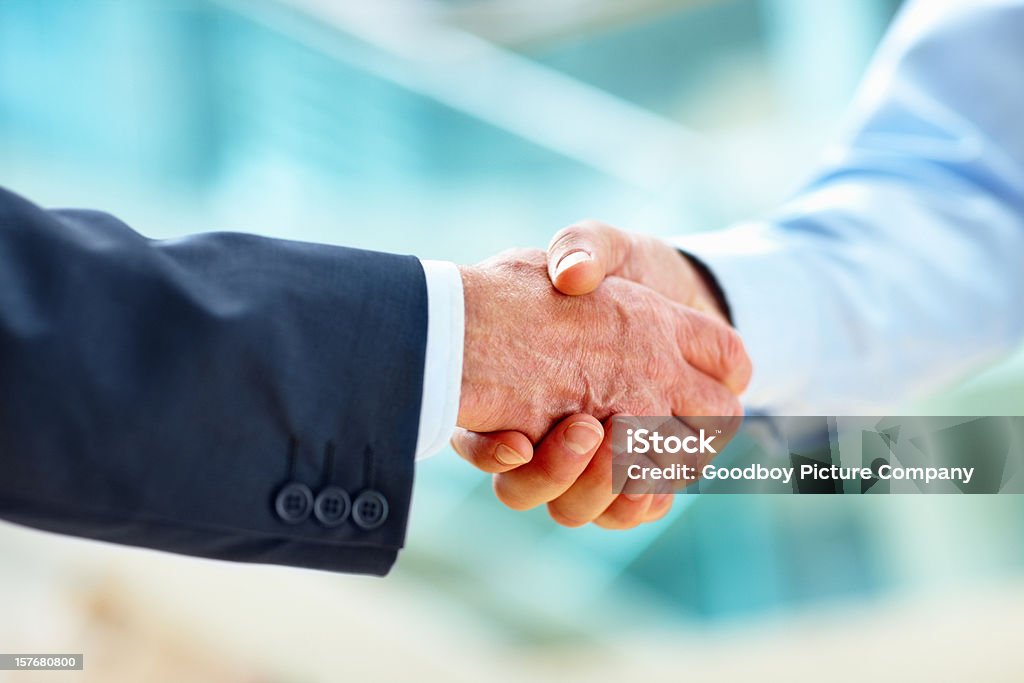 Primer plano de dos ejecutivos de negocios estrechándose las manos sobre una oferta - Foto de stock de Estrechar las manos libre de derechos