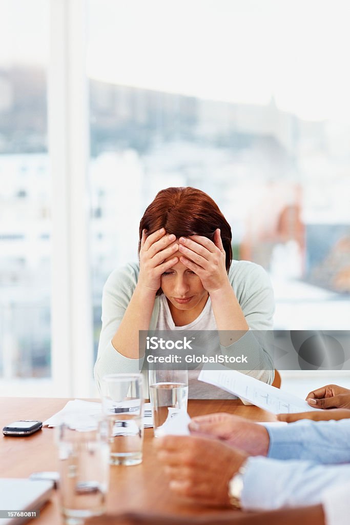 Mulher de negócios com dor de cabeça sentado em uma reunião - Foto de stock de Adulto royalty-free