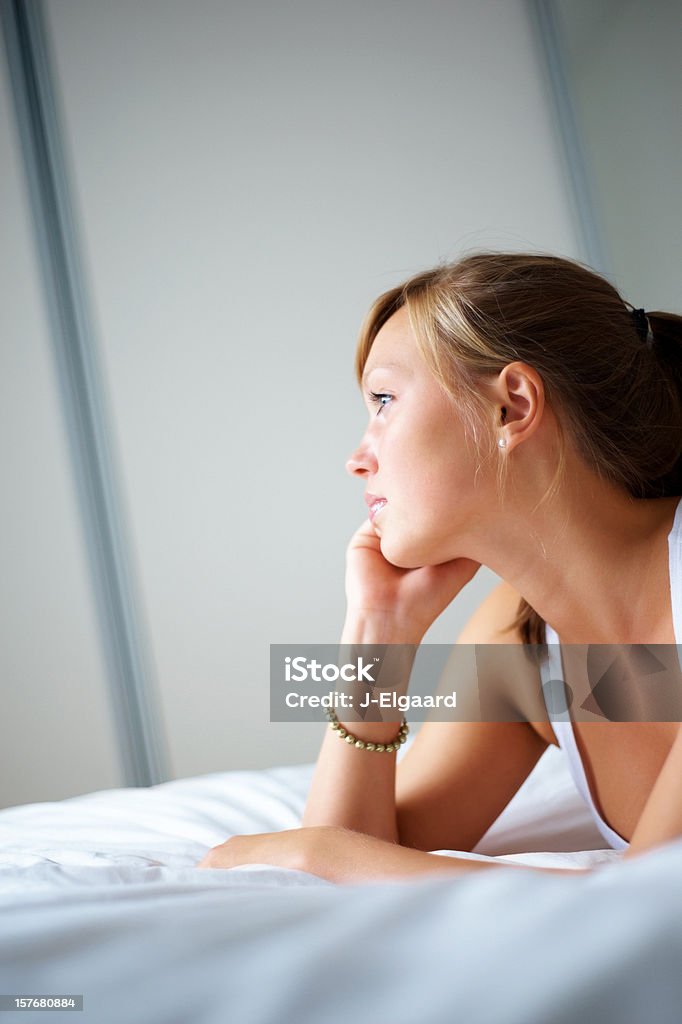 Goodlooking young female on bed looking to side or copuspace  Adult Stock Photo