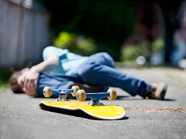 junge mit unfall auf skateboard - skateboard skateboarding outdoors sports equipment stock-fotos und bilder
