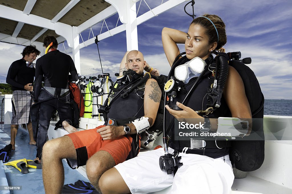 Pareja joven preparando para un horario para practicar buceo - Foto de stock de Buceo con equipo libre de derechos