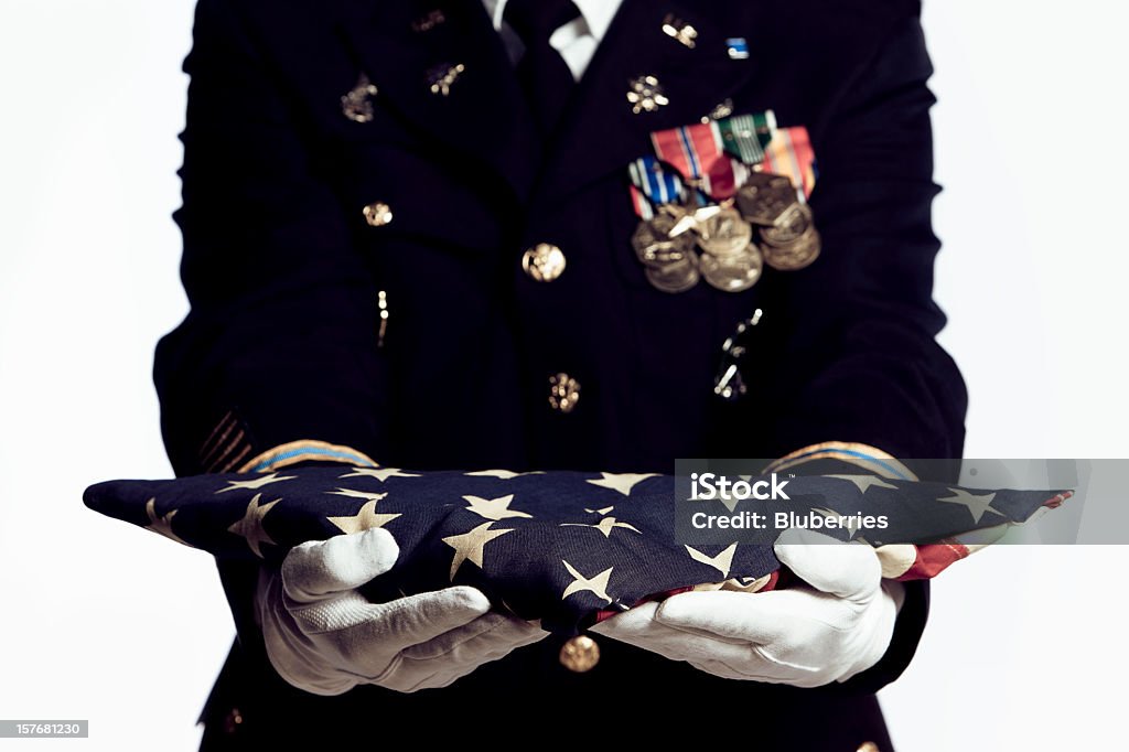 With Respect Army Soldier presenting folded USA flag. Focus on front of flag. Funeral Stock Photo