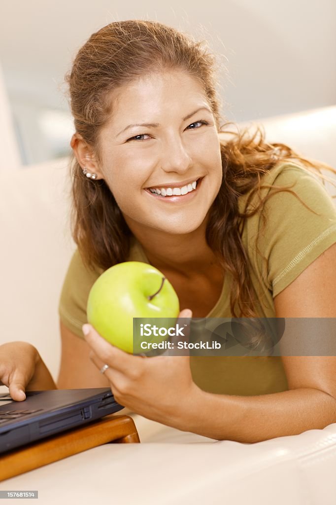 Junge Frau benutzt einen computer zu Hause - Lizenzfrei Apfelsorte Granny Smith Stock-Foto