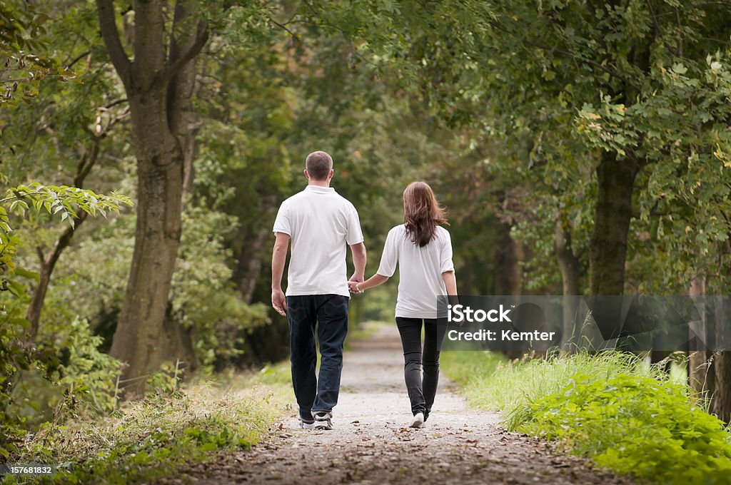 Casal jovem caminhando no parque - Foto de stock de Andar royalty-free