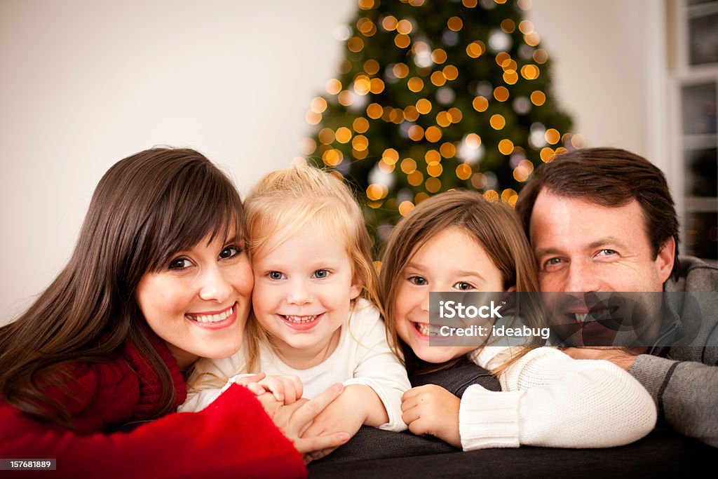 Feliz família sorridente no sofá com Árvore de Natal e luzes - Royalty-free Abraçar Foto de stock