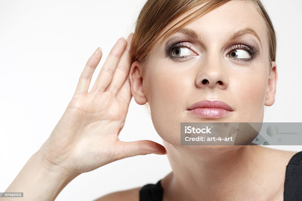 Молодая женщина с cupping руку позади уха и Подслушивать - Стоковые фото Слушать роялти-фри