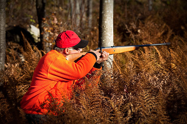 istock Senior Hunter In Forest Aiming Rifle at Sunset 157682061