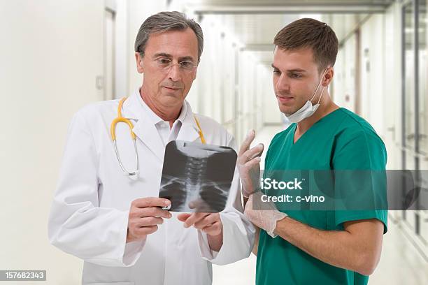 Foto de Dois Cirurgiões Verificando Um Radiography e mais fotos de stock de Cirurgião - Cirurgião, Discos intervertebrais, Coluna Vertebral - Vértebra
