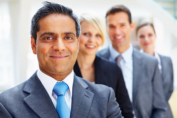 istock Business executive smiling with colleagues in the background 157682397