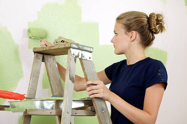 Paint Ladder and Girl Green eyed mid-teen girl  holds a paint roller as she paints her room green facing away from the camera 15 year old blonde girl stock pictures, royalty-free photos & images