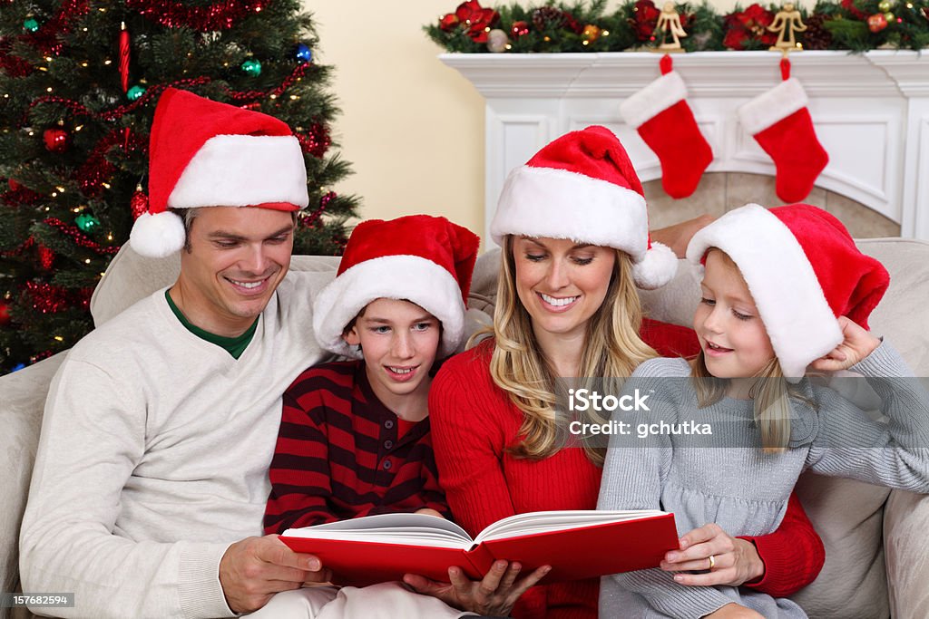 Семья читать «Рождественская история» - Стоковые фото Книга роялти-фри