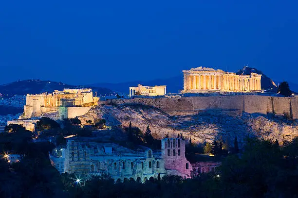 The Acropolis in Athens with the Theater of Herodes Atticus in the foreground and the Propylaea, the Erechtheum and the Parthenon on the mountain top.