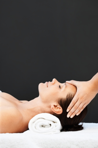 Mujer de mediana edad recibir masaje de cabeza sobre fondo negro photo