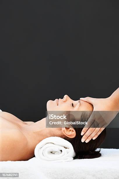 Mid Adult Woman Receiving Head Massage On Black Background Stock Photo - Download Image Now