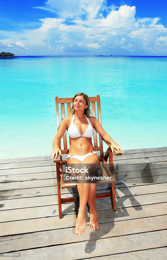 女性の椅子に座って、エキゾチックなリゾートで - 1人のロイヤリティフリーストックフォト