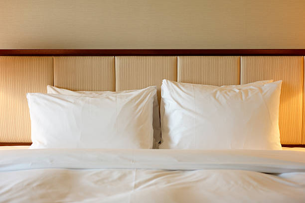 Close-up of white linens over a luxury hotel bed stock photo