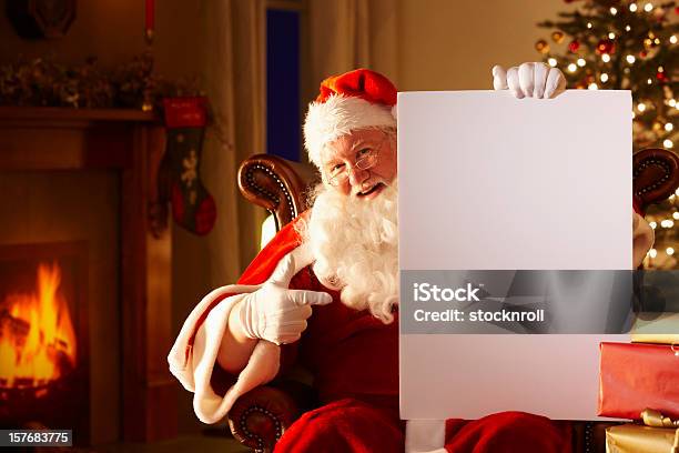 Jolly Отец Держит Белая Доска Рождество — стоковые фотографии и другие картинки Санта Клаус - Санта Клаус, Сидеть, Стулья