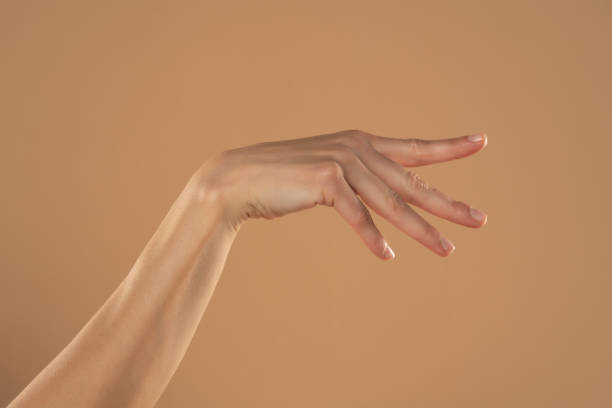 istock Female hand and palm isolated on beige background 1576838322
