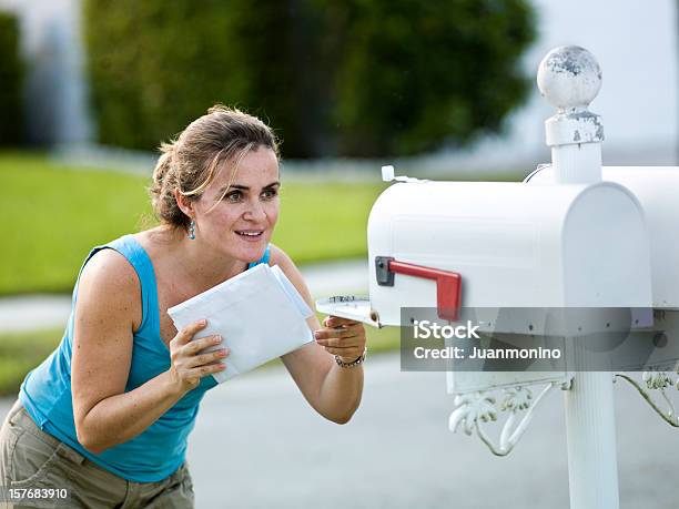 Eine Weiße Frau Holding Buchstabenlooks In Einen Briefkasten Stockfoto und mehr Bilder von Briefkasten