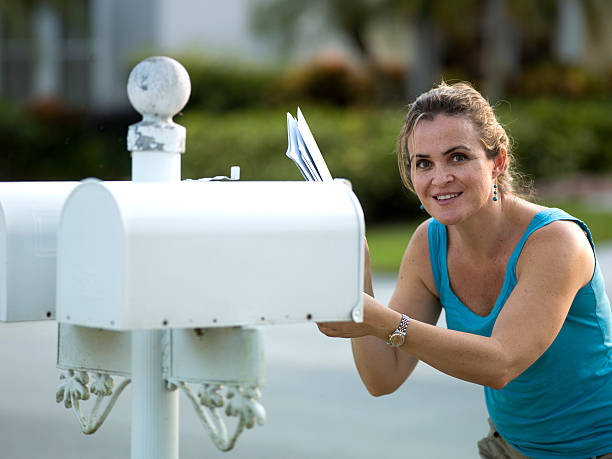 femme de soulever courrier - women suburb mailbox curiosity photos et images de collection