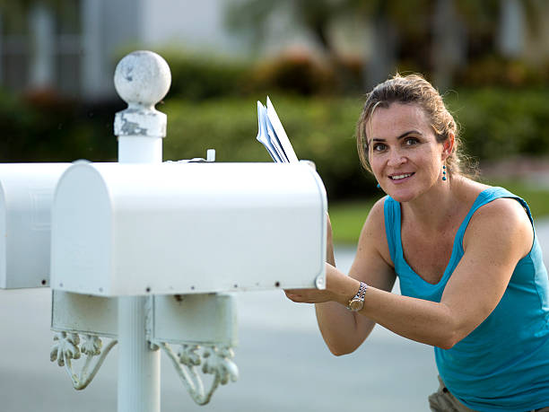 kobieta odbiera wiadomości - mailbox mail junk mail opening zdjęcia i obrazy z banku zdjęć